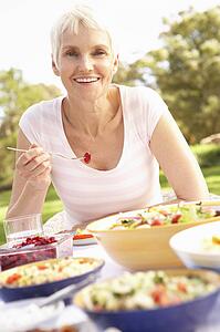 Senior Woman Enjoying Meal In Garden