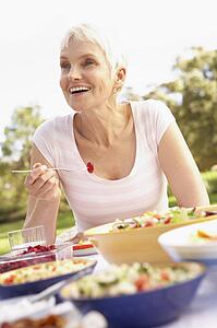 Senior Woman Enjoying Meal In Garden