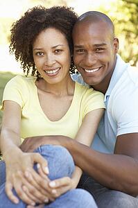 Portrait Of Young Couple Sitting In Park