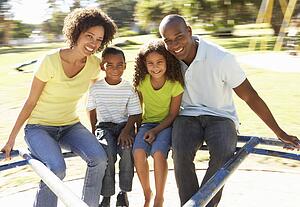 Family In Park Riding On Roundabout