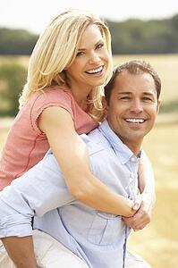 Couple Having Piggyback In Summer Harvested Field