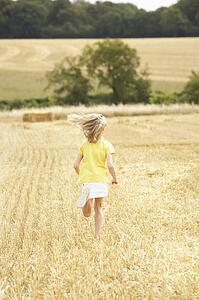 Girl Running Through Summer Harvested Field