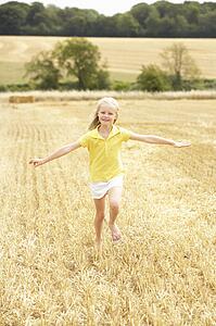 Girl Running Through Summer Harvested Field