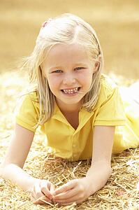 Portrait Of Girl Laying In Summer Harvested Field