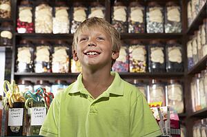 Excited Boy Standing In Sweet Shop