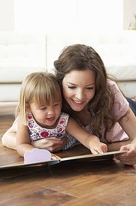 Mother And Daughter Learning To Read At Home