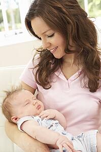 Close Up Of Affectionate Mother Cuddling Baby Boy At Home