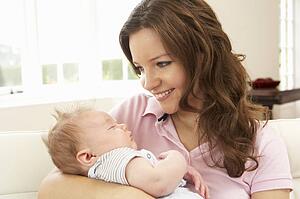 Close Up Of Affectionate Mother Cuddling Baby Boy At Home