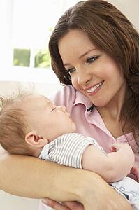 Close Up Of Affectionate Mother Cuddling Baby Boy At Home