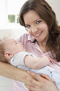 Close Up Of Affectionate Mother Cuddling Baby Boy At Home