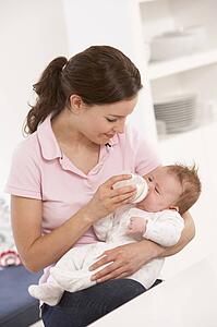 Mother Giving Bottle Baby Boy At Home