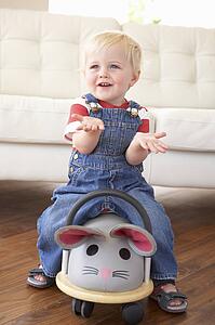 Young Boy Playing With Ride On Toy Mouse At Home