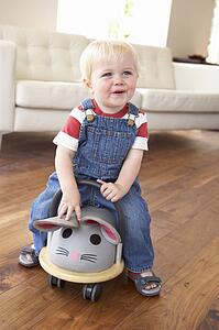 Young Boy Playing With Ride On Toy Mouse At Home