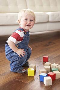 Young Boy Playing With Coloured Blocks At Home