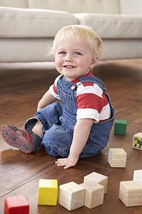 Young Boy Playing With Coloured Blocks At Home