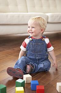 Young Boy Playing With Coloured Blocks At Home