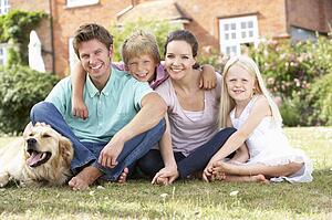 Family Sitting In Garden Together
