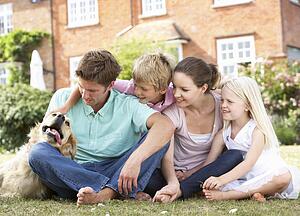 Family Sitting In Garden Together