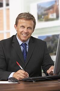 Male Estate Agent Working At Desk