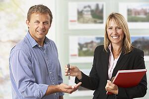 Female Estate Handing Over Keys Of New Home To Client