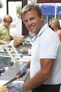 Man Working Behind Counter In Café