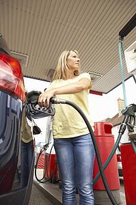 Female Motorist Filling Car With Diesel At Petrol Station