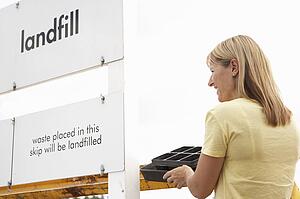 Woman At Recycling Centre Disposing Of Cardboard