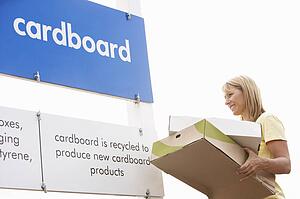 Man At Recycling Centre Disposing Of Cardboard
