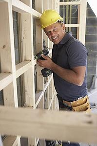 Construction Worker Building Timber Frame In New Home