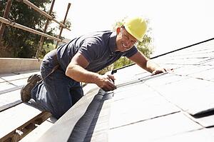 Roofer Working On Exterior Of New Home
