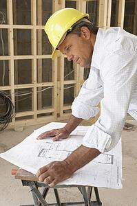 Architect Studying Plans In New Home
