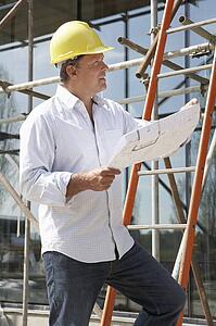 Architect Studying Plans Outside New Home