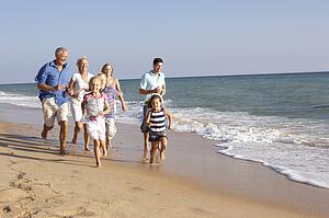Portrait Of Three Generation Family On Beach Holiday