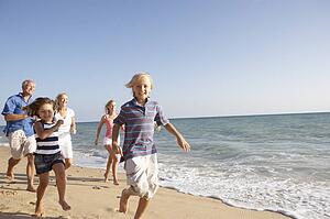 Portrait Of Three Generation Family On Beach Holiday