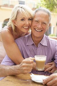 Senior Couple Enjoying Coffee And Cake In Café