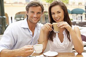 Young Couple Enjoying Coffee And Cake In Café