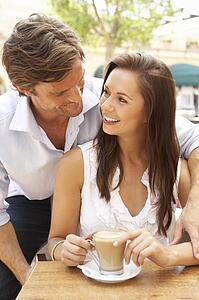 Young Couple Enjoying Coffee And Cake In Café