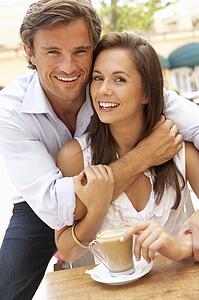 Young Couple Enjoying Coffee And Cake In Café