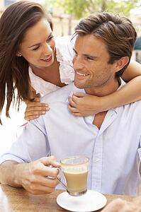 Young Couple Enjoying Coffee And Cake In Café