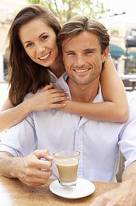 Young Couple Enjoying Coffee And Cake In Café