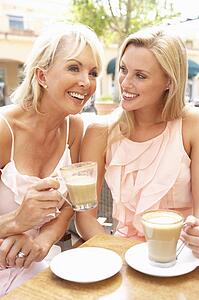 Two Women Enjoying Cup Of Coffee In Café