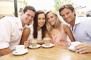 Group Of FriendsEnjoying Coffee In Café