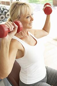 Senior Woman Working With Weights In Gym
