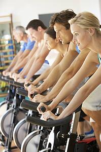 Man Cycling In Spinning Class In Gym