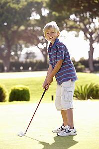Young Boy Practising Golf On Putting On Green