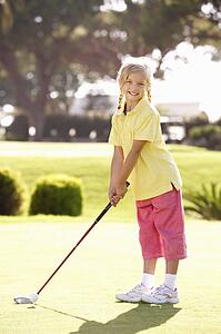 Young Girl Practising Golf On Putting On Green