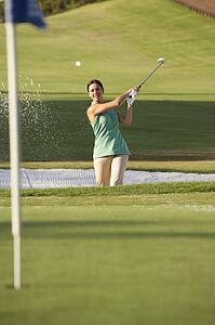 Male Golfer Playing Bunker Shot On Golf Course