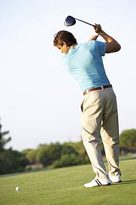 Male Golfer Teeing Off On Golf Course