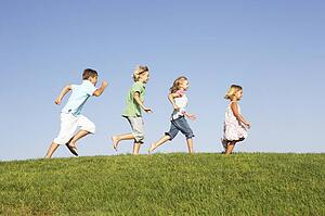 Young children running through field