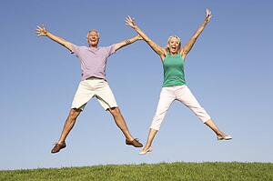 Senior couple jumping in air